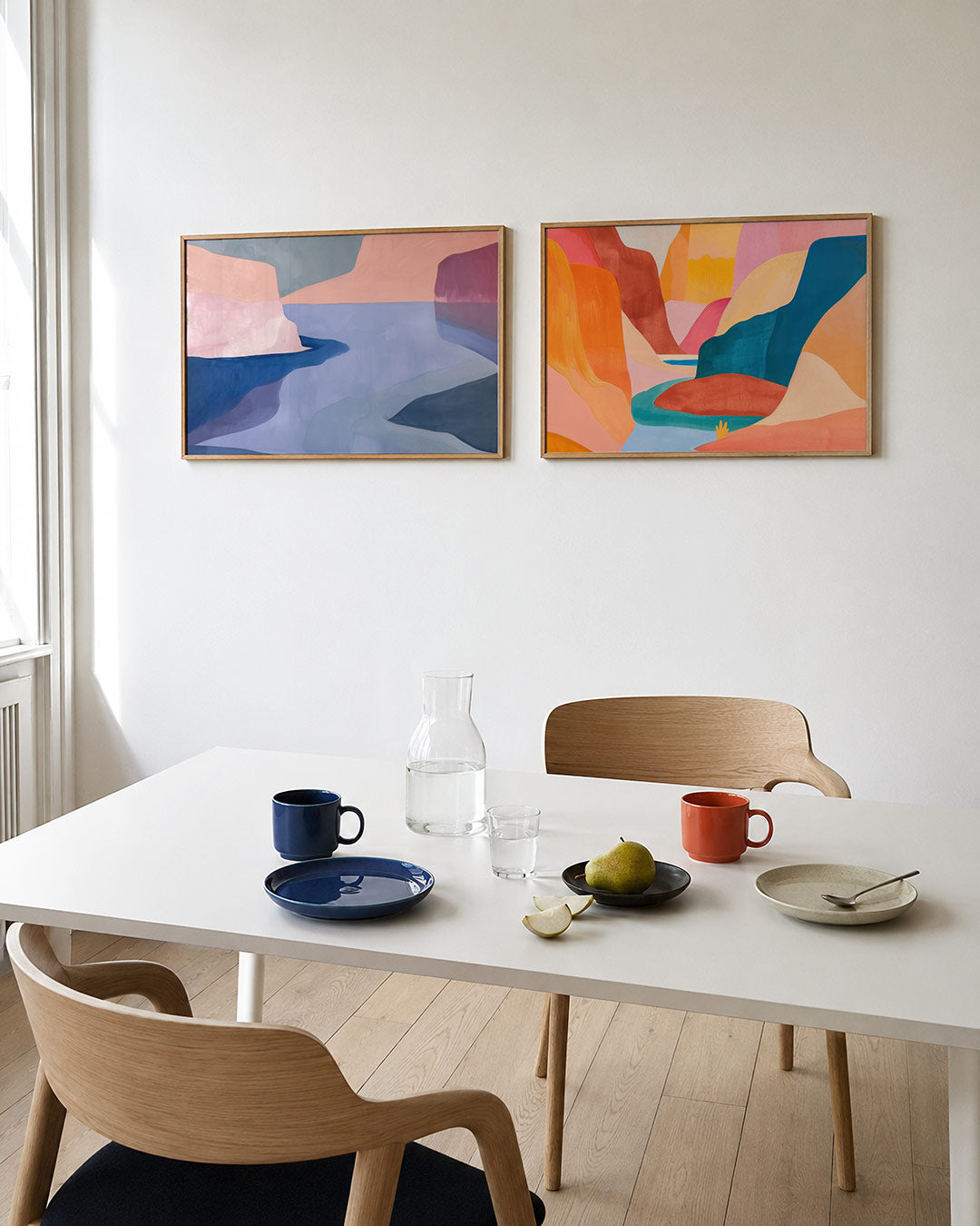 Interieurpresentatie van twee posters met vloeiende vormen en zachte kleurvlakken in roze, blauw en grijs