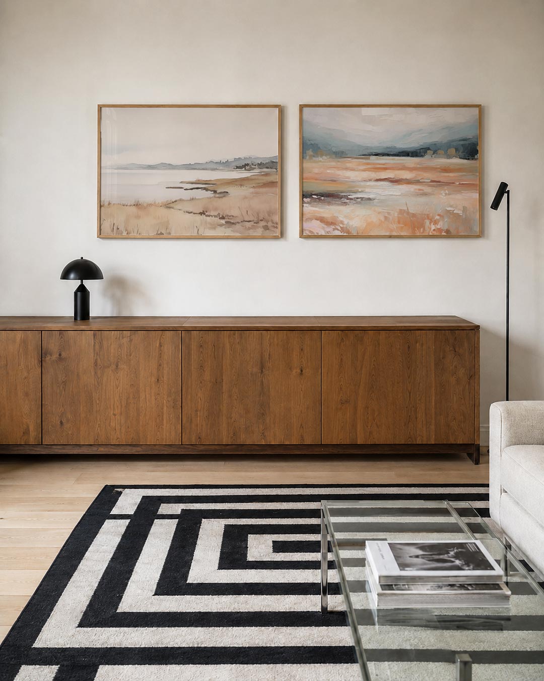 Twee liggende posters met een kustlijn in zachte tinten van beige en blauw, aan de muur in een interieur