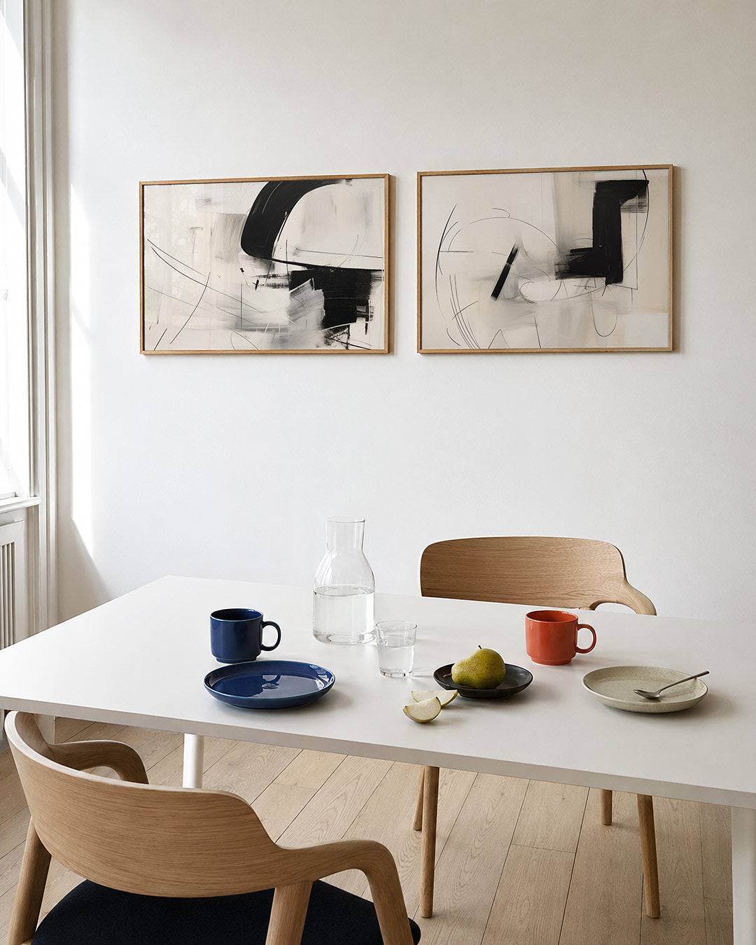 Tweedelige posterset met een spel van zwarte en witte vlakken met vloeiende lijnen, getoond in een interieur