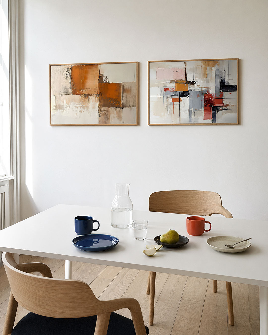 Twee liggende posters met een spel van warme oranje en beige vlakken, aan de muur in een interieur