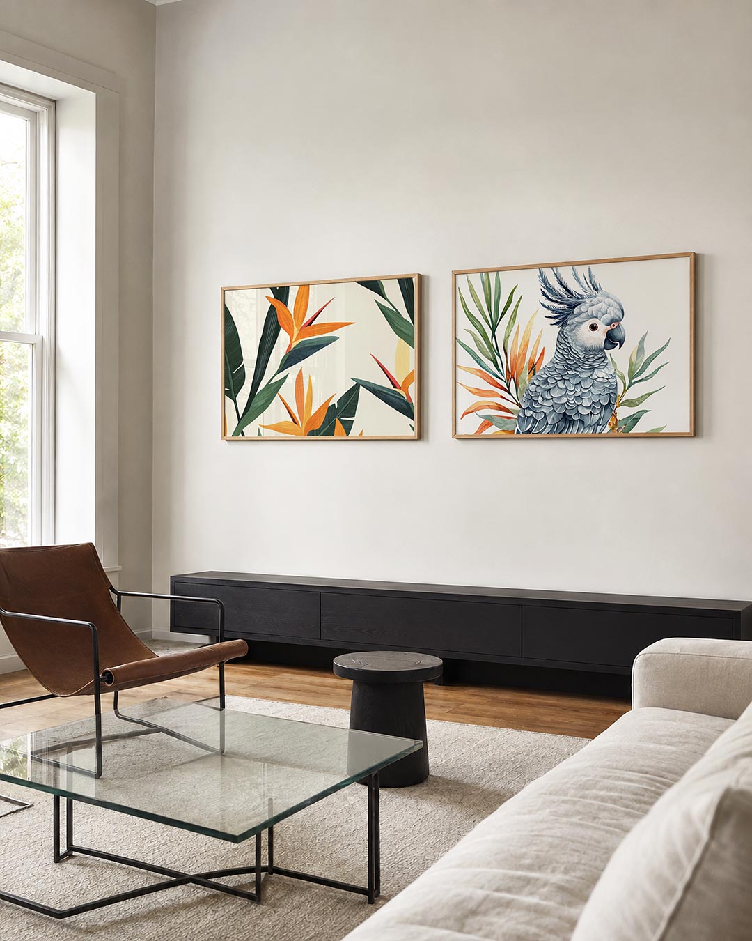 Twee liggende posters met oranje bloemen en donkergroene bladeren tegen een lichte achtergrond, aan de muur in een interieur
