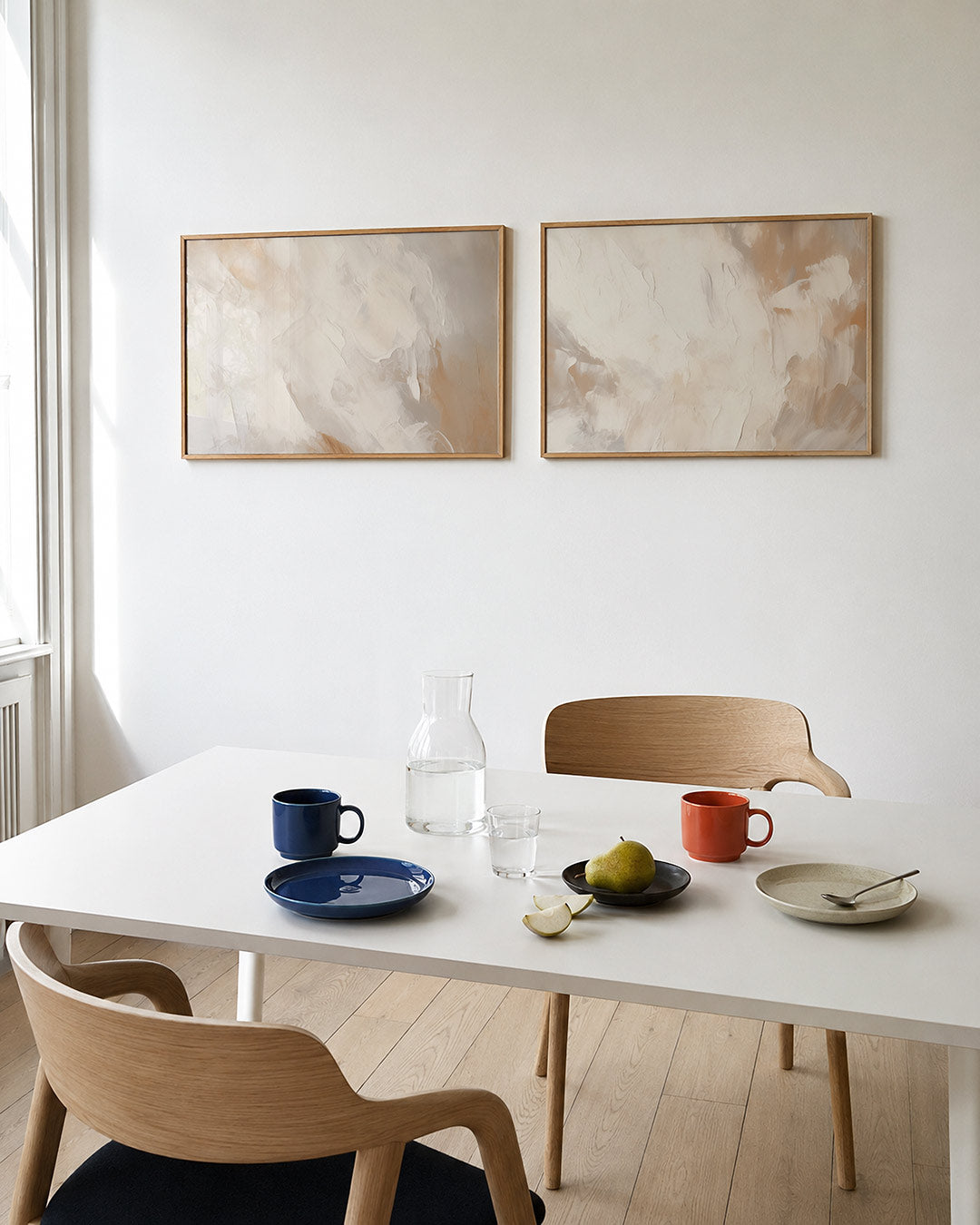 Tweedelige posterset met vloeiende, zachte kleurvlakken in crèmetinten, getoond in een interieur