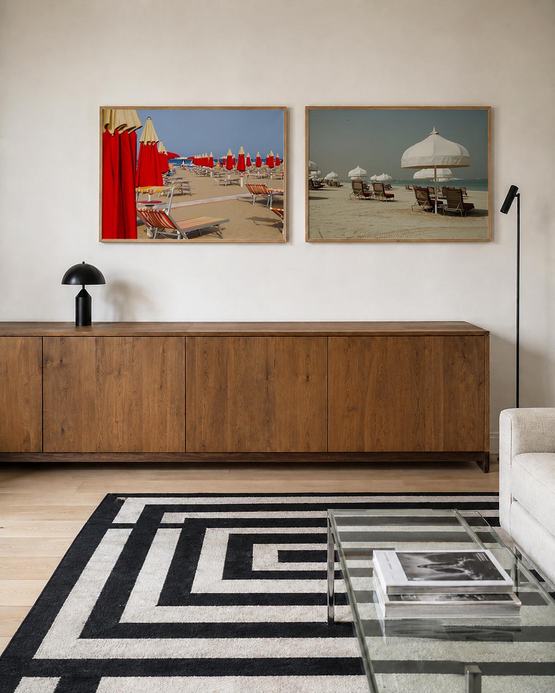 Interieurbeeld met twee liggende posters: rode parasols en ligbedden op een zonnig strand