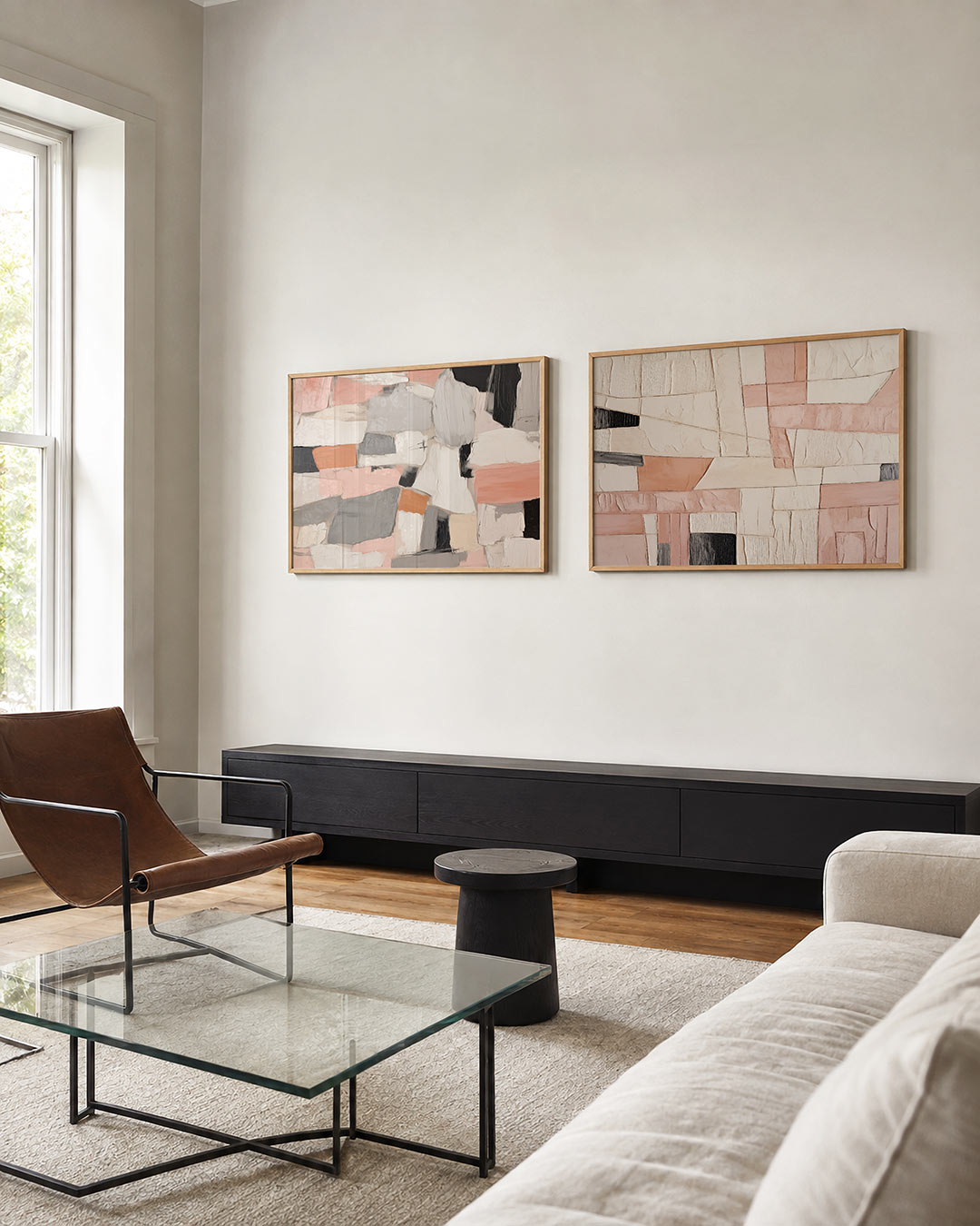 Twee liggende posters met rechthoekige kleurvlakken in zachte tinten roze, grijs, zwart en wit, aan de muur in een interieur