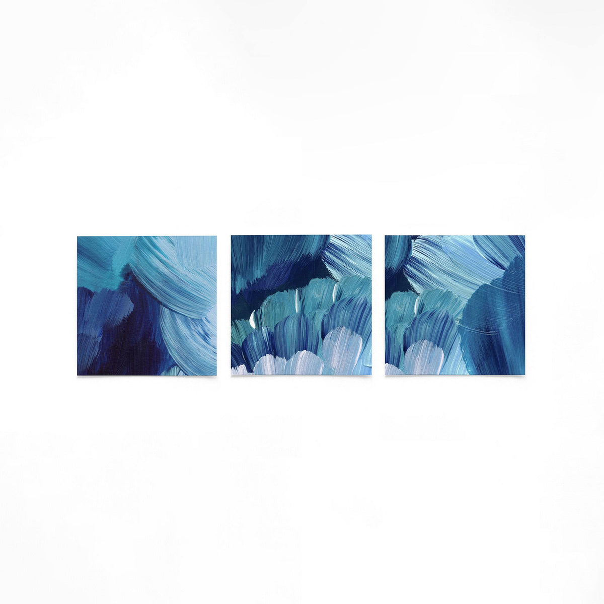 Drie vierkante posters met blauwe abstracte op een gebroken witte achtergrond
