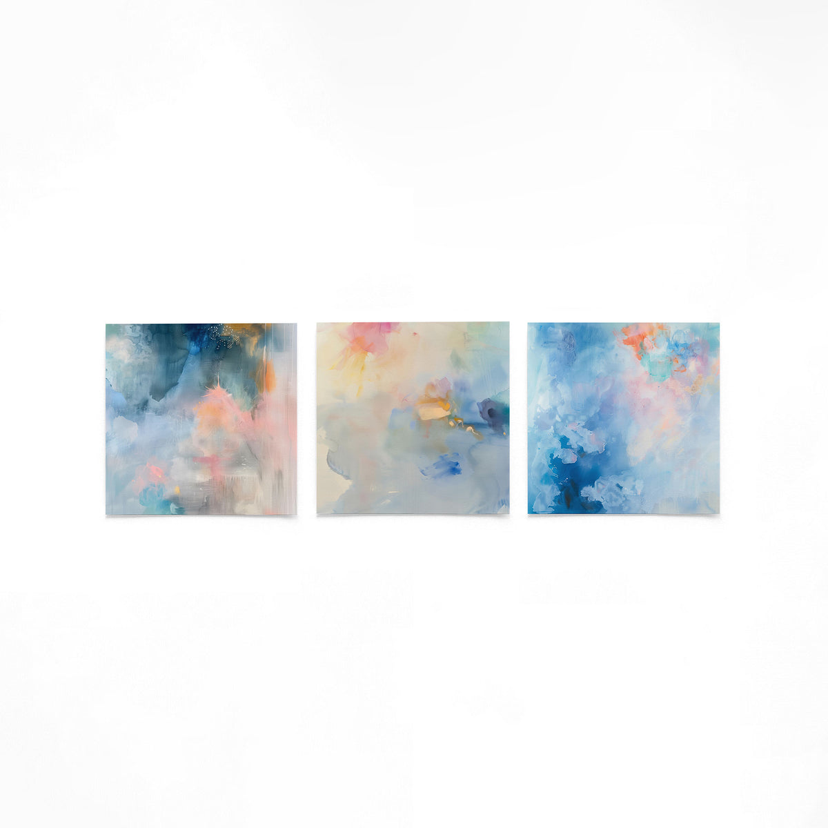 Drie vierkante posters met abstracte blauwe schilderingen op een gebroken witte achtergrond