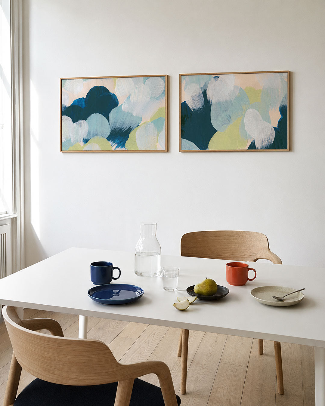 Interieurbeeld met twee liggende posters: zachte, ronde vormen in blauw, groen en wit