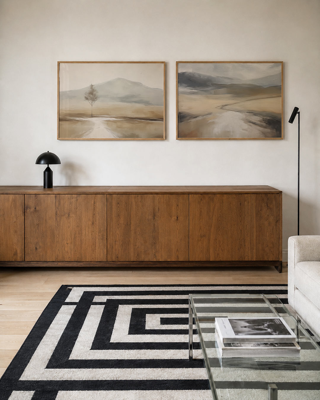 Twee liggende posters met een eenzame boom in een uitgestrekt landschap, aan de muur in een interieur