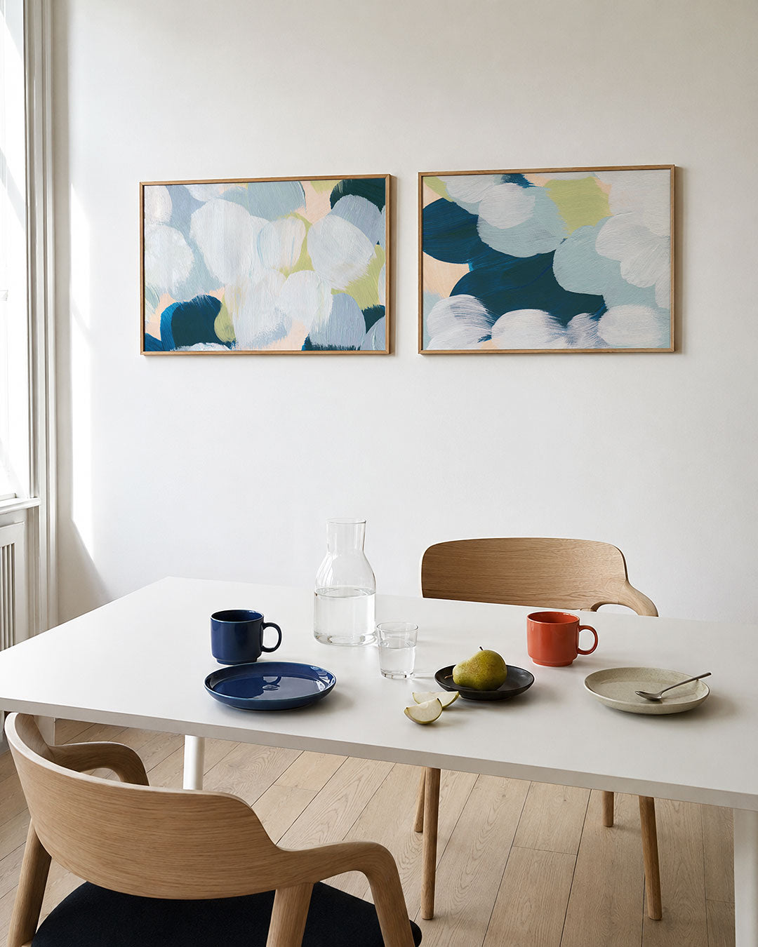 Tweedelige posterset met zachte penseelstreken in blauw, groen en wit, getoond in een interieur