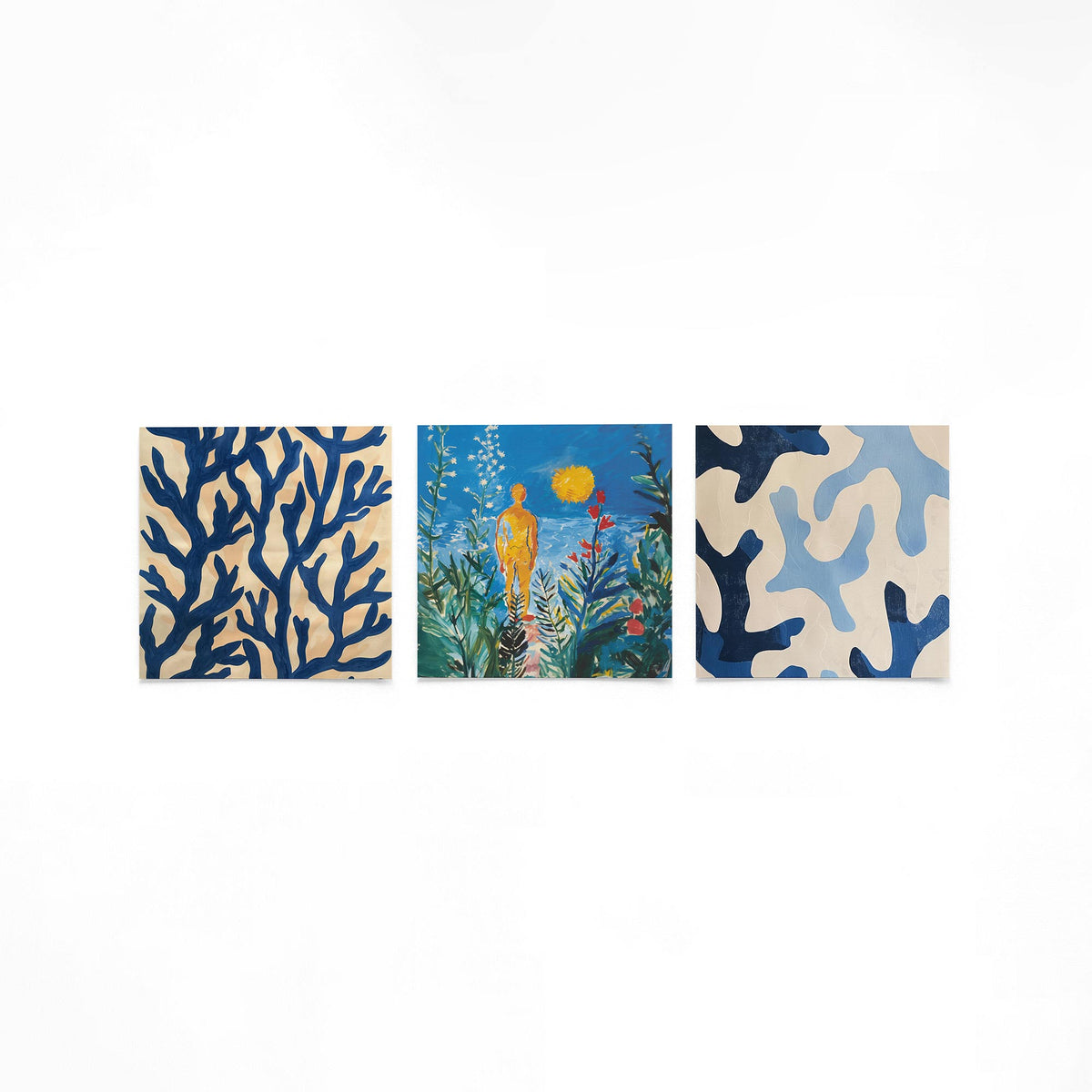 Drie vierkante posters met abstracte blauwe patronen op een gebroken witte achtergrond