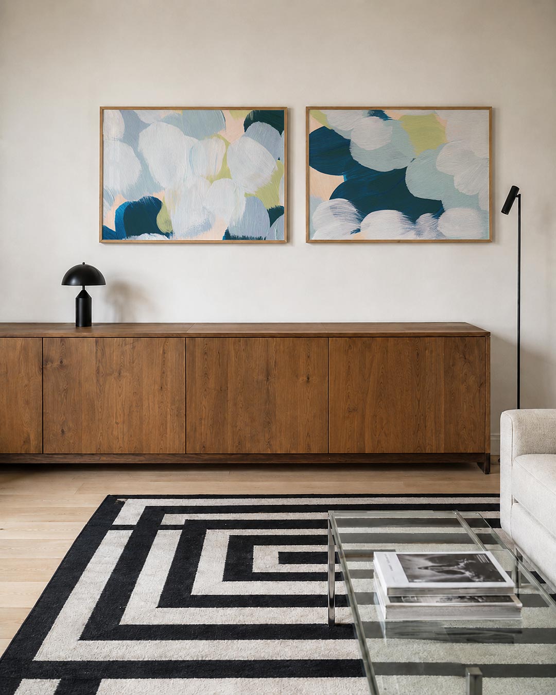 Twee liggende posters met zachte penseelstreken in blauw, groen en wit, aan de muur in een interieur