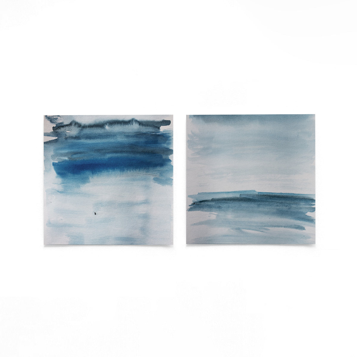 Twee vierkante posters met blauwe penseelstreken op een gebroken witte achtergrond