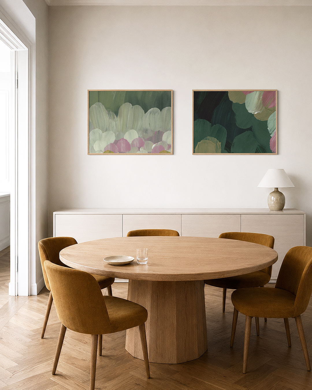 Twee liggende posters met zachte penseelstreken in groen, wit en roze, aan de muur in een interieur