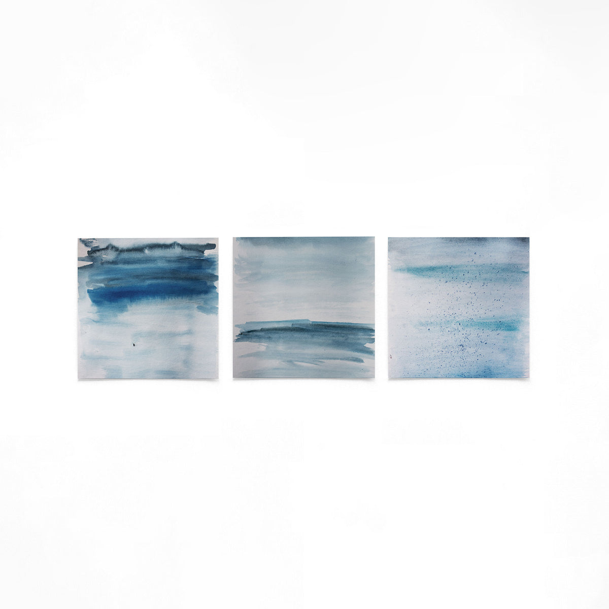 Drie vierkante posters met blauwe abstracte op een gebroken witte achtergrond