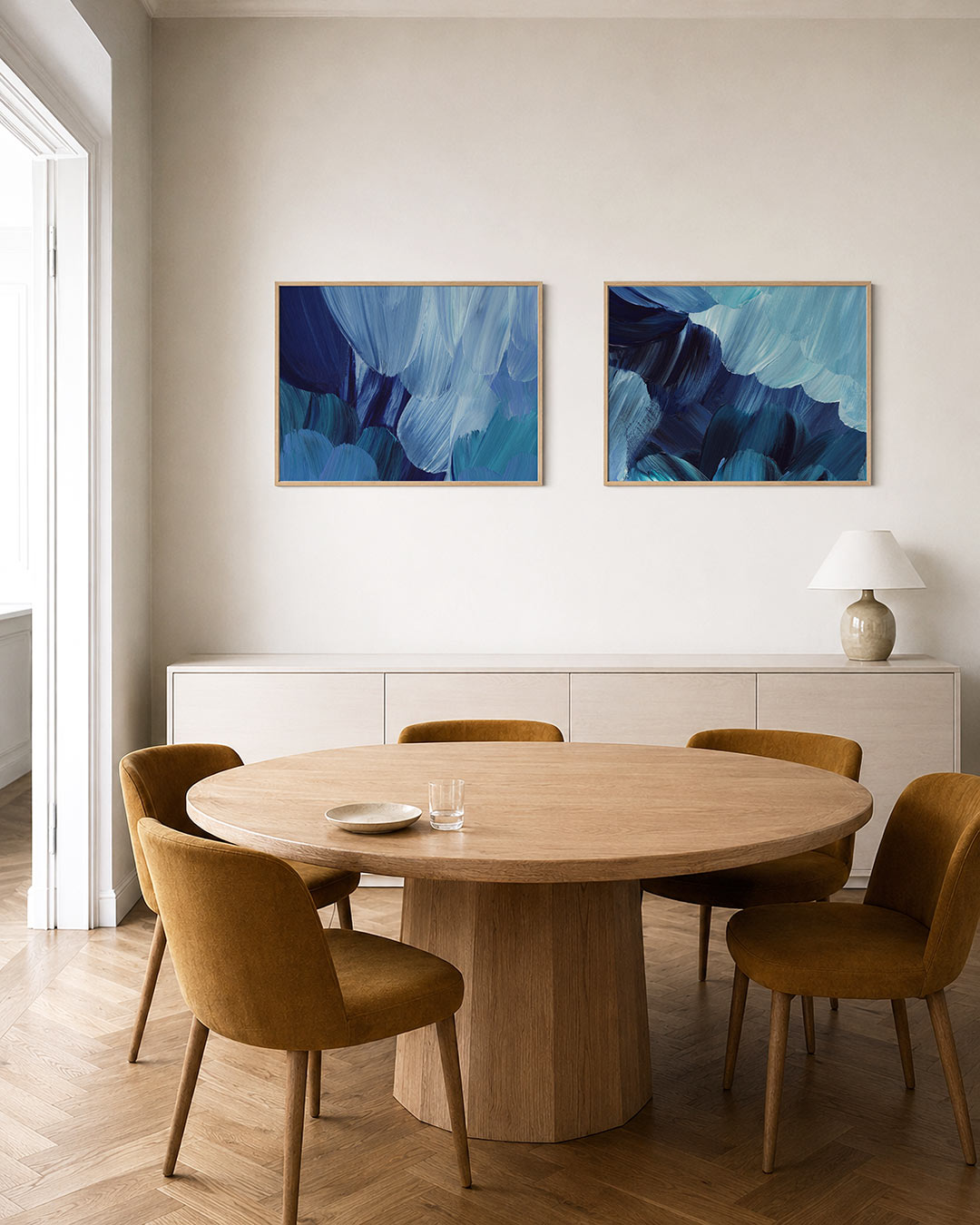 Interieurbeeld met twee liggende posters: vloeiende blauwe penseelstreken die elkaar overlappen