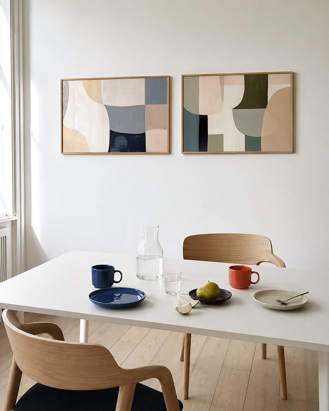 Twee liggende posters met vloeiende lijnen en zachte kleurvlakken in beige, wit en blauwgrijs, aan de muur in een interieur