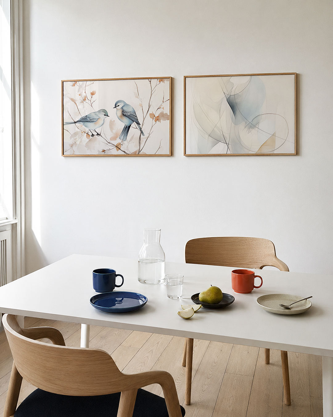 Twee liggende posters met twee vogels op takken, omgeven door zachte bladeren, aan de muur in een interieur