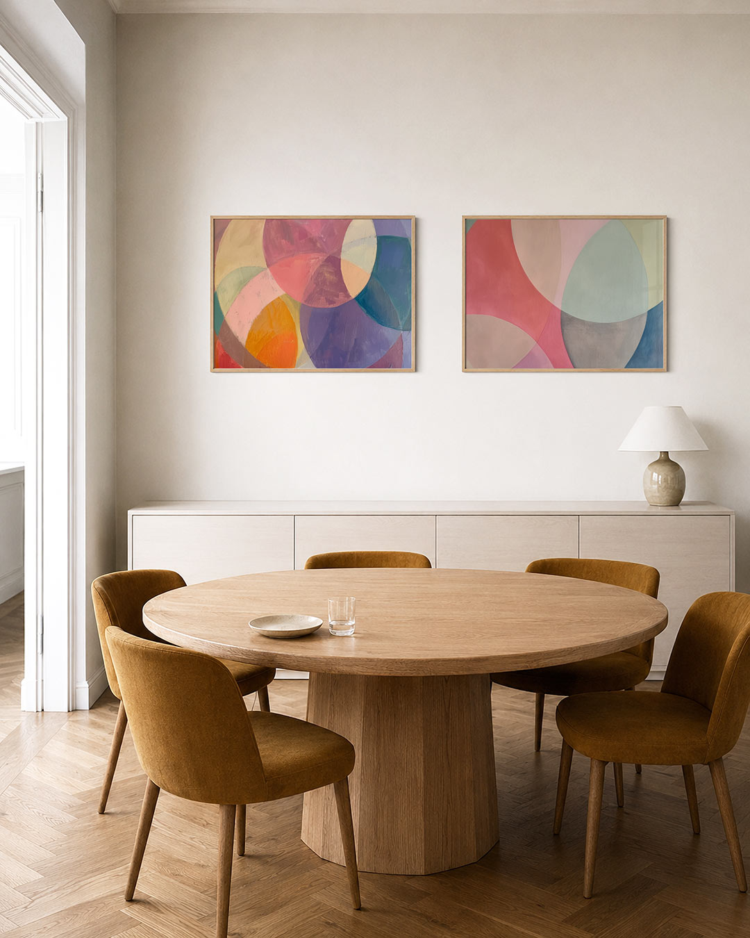 Interieurpresentatie van twee posters met overlappende cirkels in zachte tinten roze, paars, geel en blauw