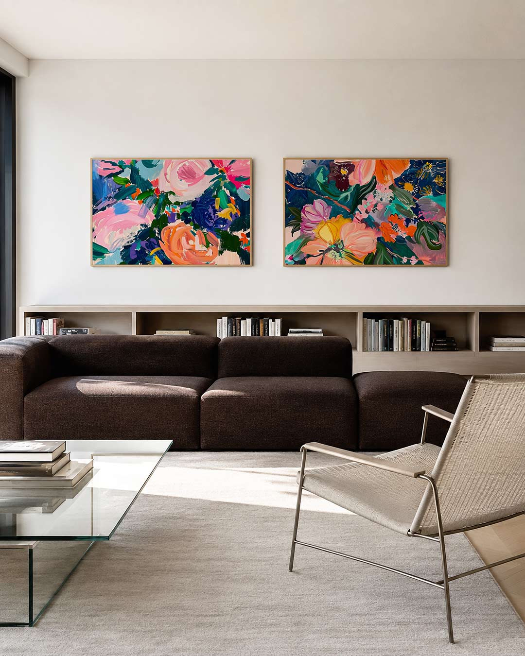 Twee liggende posters met roze, blauw en groen, aan de muur in een interieur